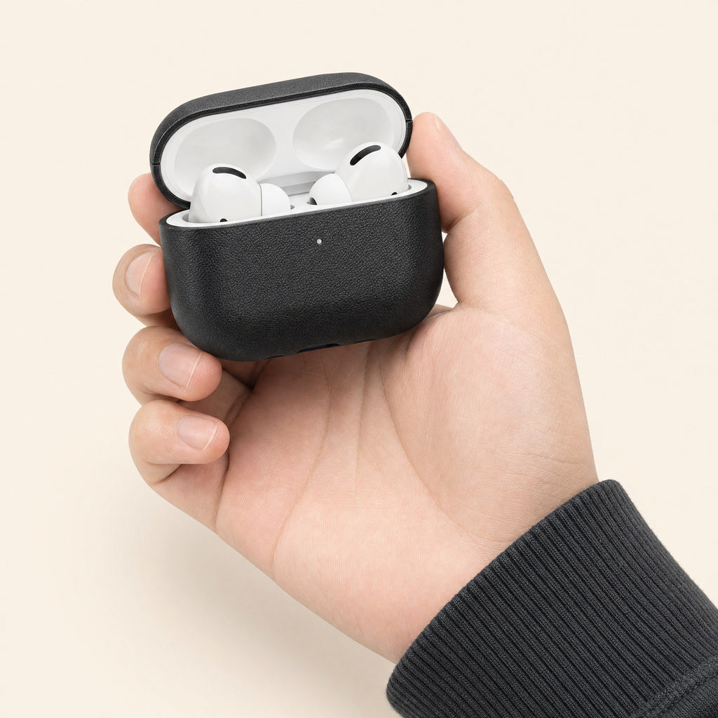 The case held open in one hand with the earbuds inside