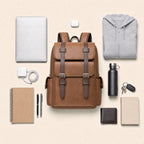 Light brown leather backpack with everything it carries, laid out