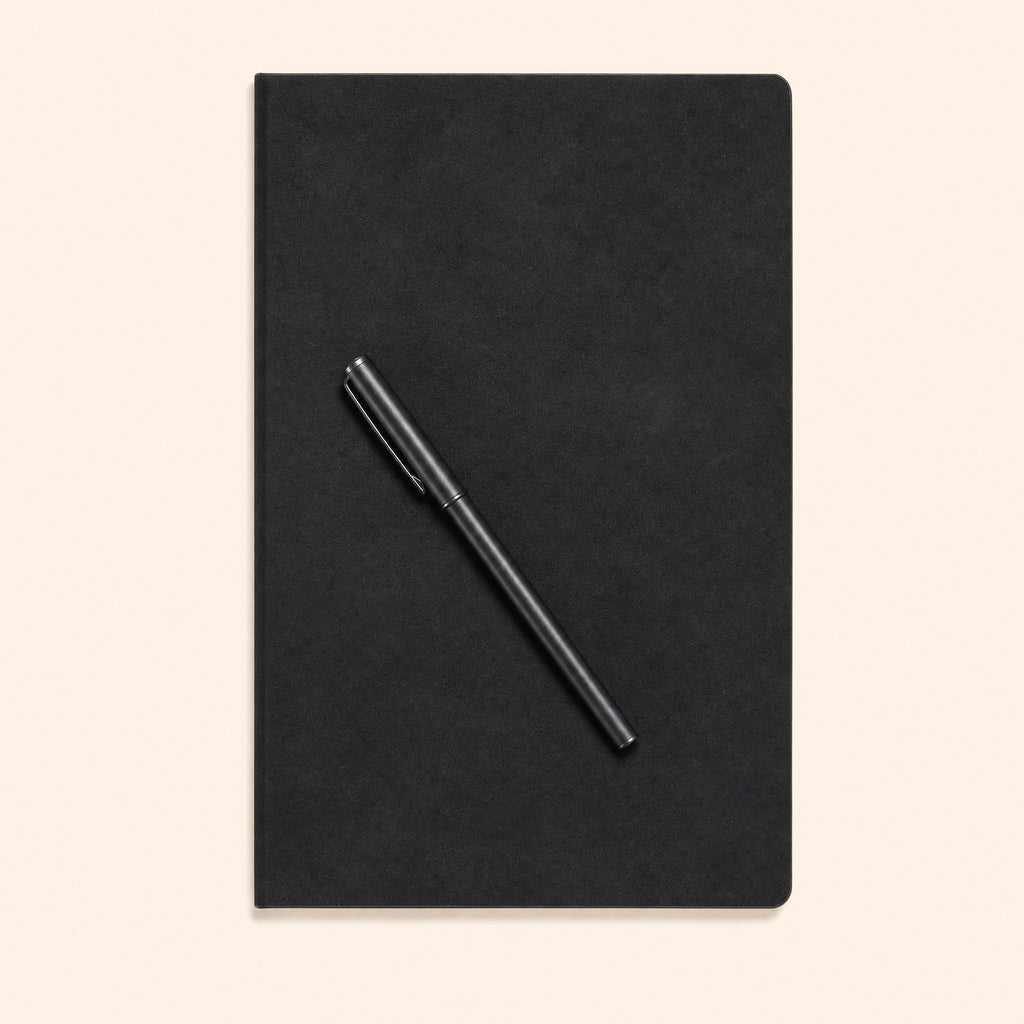 The closed notebook with a pen resting across the cover