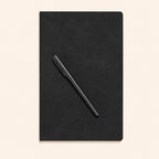 The closed notebook with a pen resting across the cover